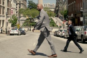 a man in a suit walking across the street