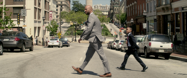 a man in a suit walking across the street