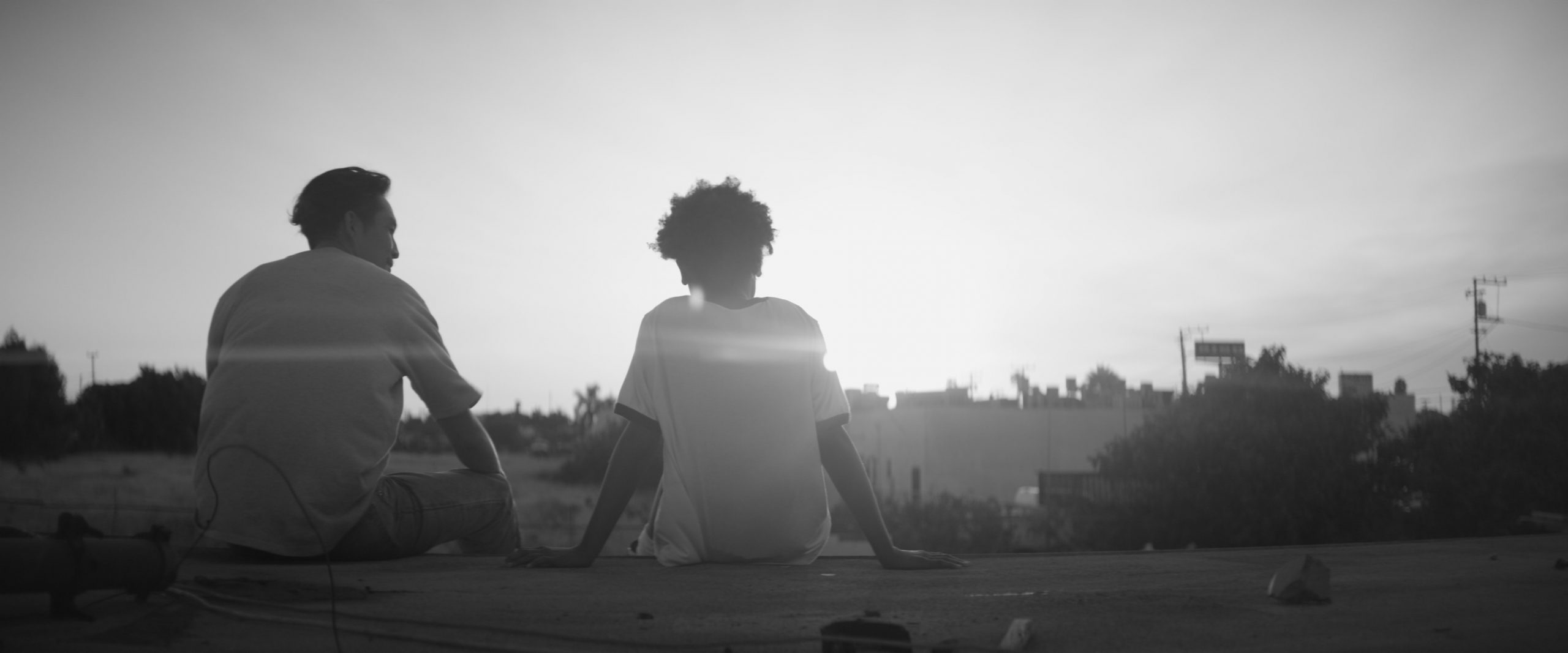 Black and white image of a man and a child from the movie Gook. 