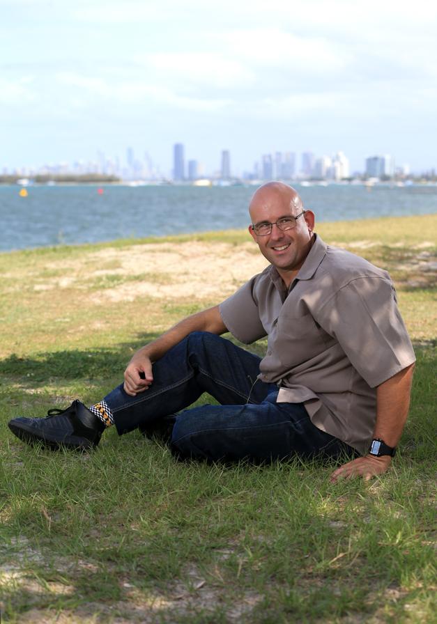 a man sits on grass and looks at the camera