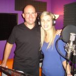 A man and a woman pose with one another in a recording studio