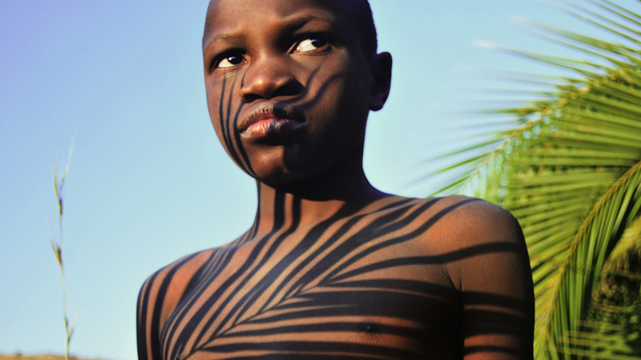 Still from Liyana: boy standing with shadows across his body