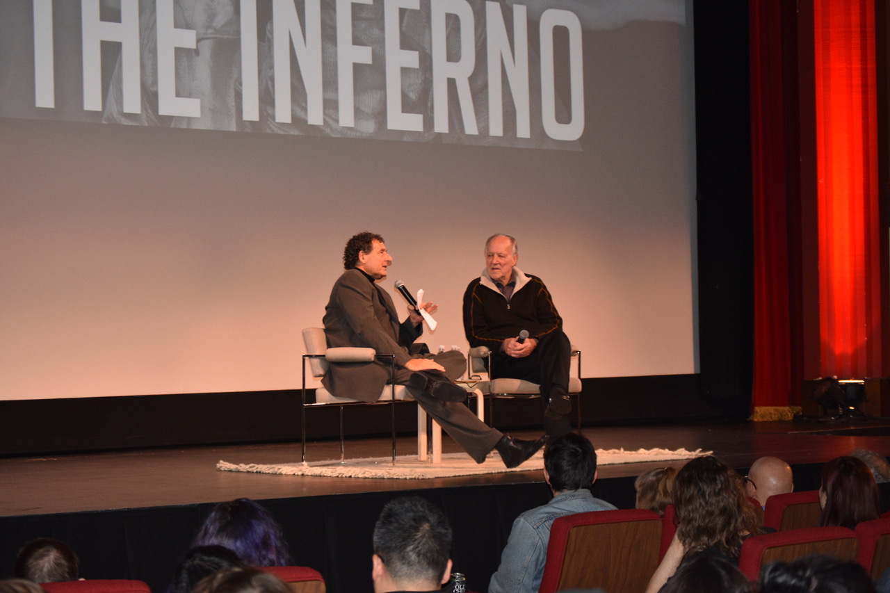 Werner Herzog talking with Professor Herbert Gelder on the podium. 