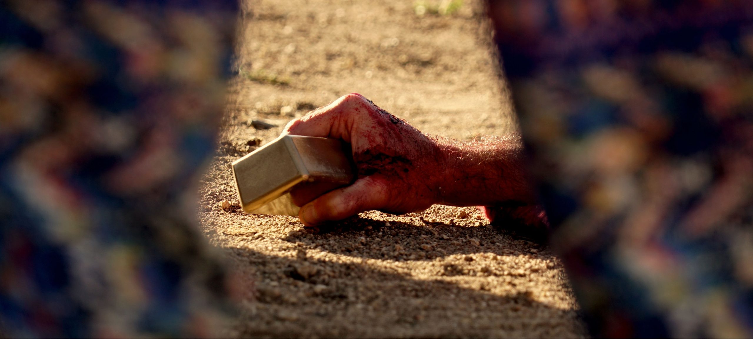 A hand holding onto a gold bar