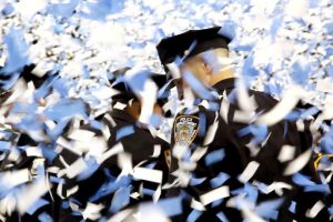 NYPD officers are covered in confetti at a police academy graduation in the documentary Crime + Punishment.