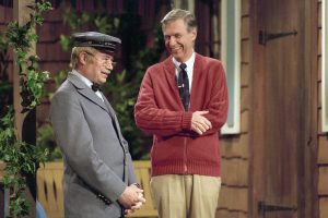 Fred Rogers and David Newell, as Speedy Delivery's Mr. McFeely, stand on the front porch set while filming an episode of Mister Rogers' Neighborhood.