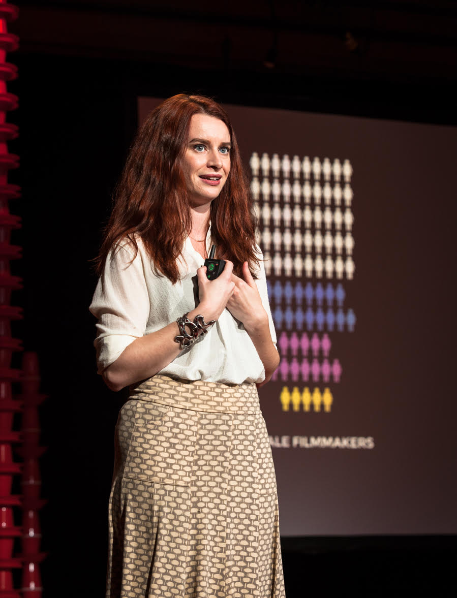 A woman standing in front of a screen