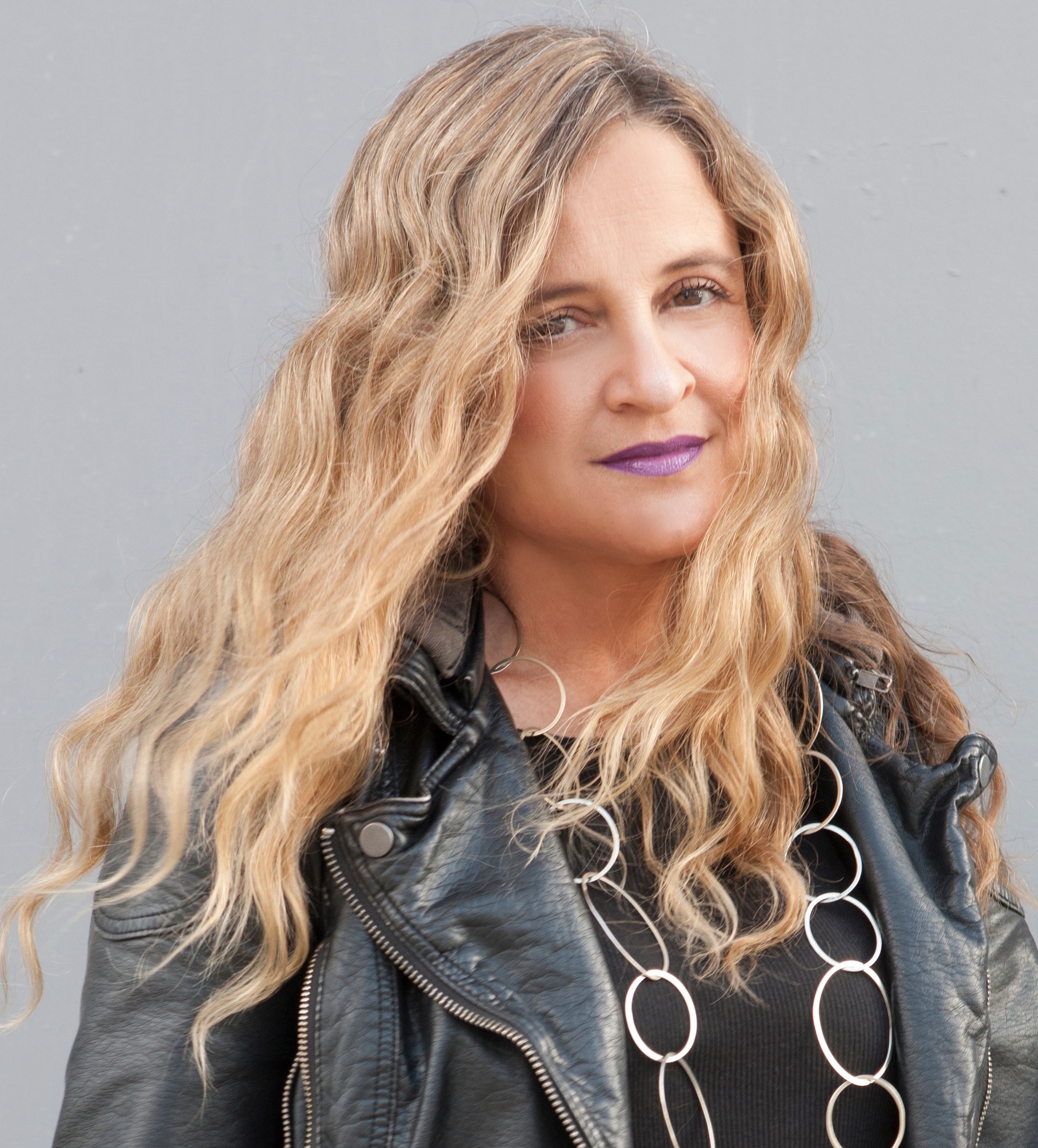 Portrait of a blonde woman in a leather jacket, filmmaker Christina Kallas.