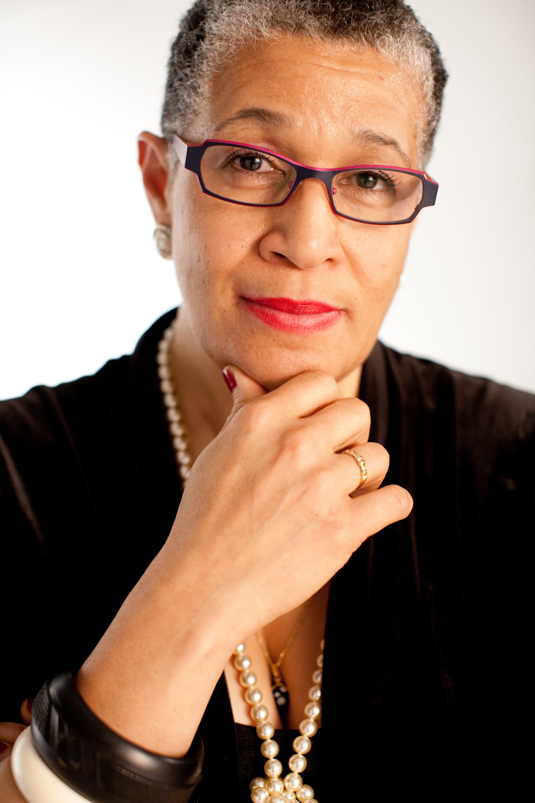 A Black woman in front of a white background.