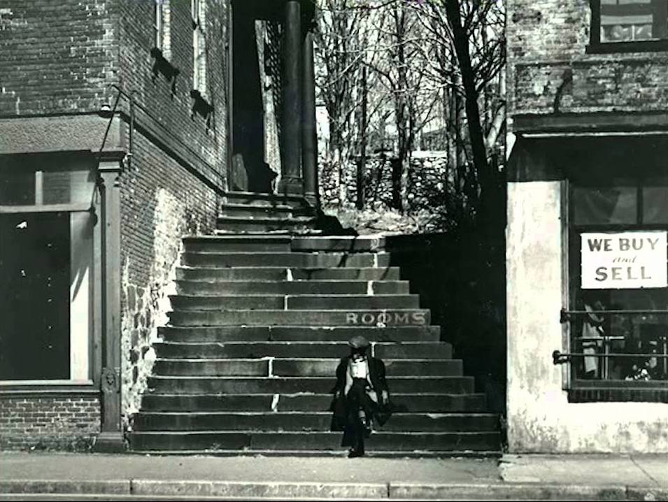 A black and white still photo of a staircase outside.