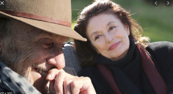 Jean-Louis Trintignant laughing with Anouk Aimee in background