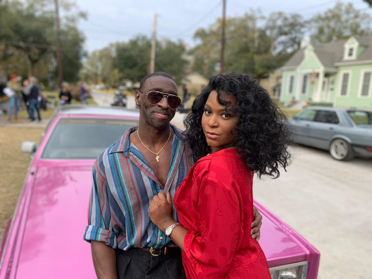 Timothy Richardson and Alexandra Grey leaning against a pink car.