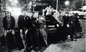 Teens leaning against a car in NYC from the 1970s.