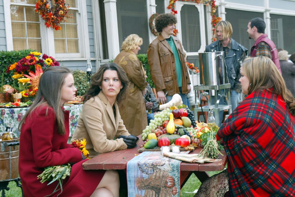 Three women sitting around a bench on Thanksgiving.