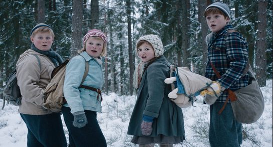 Children facing back in snowy landscape.