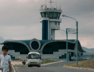 Boy walking in front of airport.