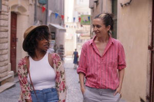 two women walking down a cobble stone street a cobble