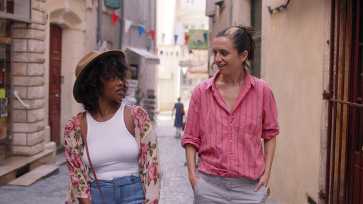 two women walking down a cobble stone street a cobble