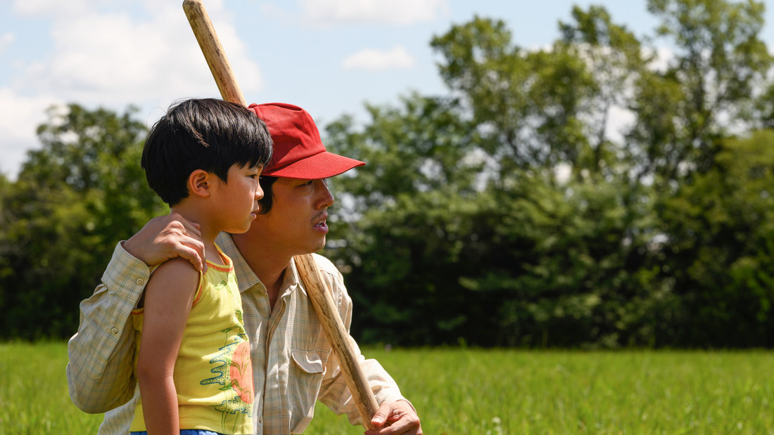 Father and son hold baseball bat.