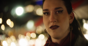 A young woman with makeup and hair in a ponytail. 