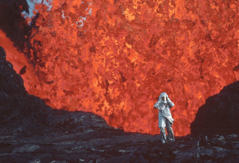 figure in front of erupting volcano