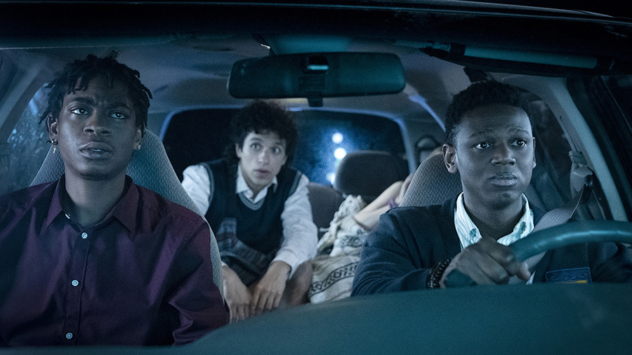 Three men in a car at night.