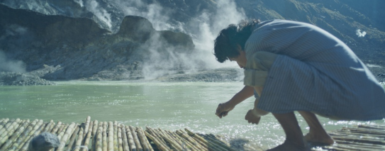 Person on raft near steam from lava meeting water.