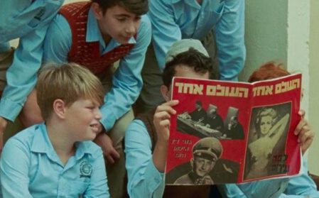 CHILDREN READING TABLOID