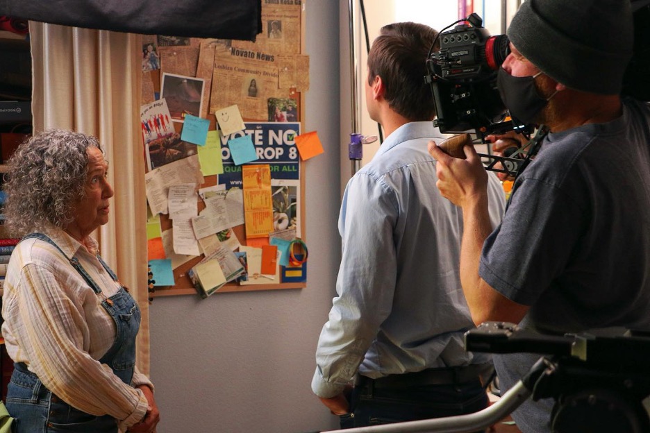 Three people staring at a corkboard collage