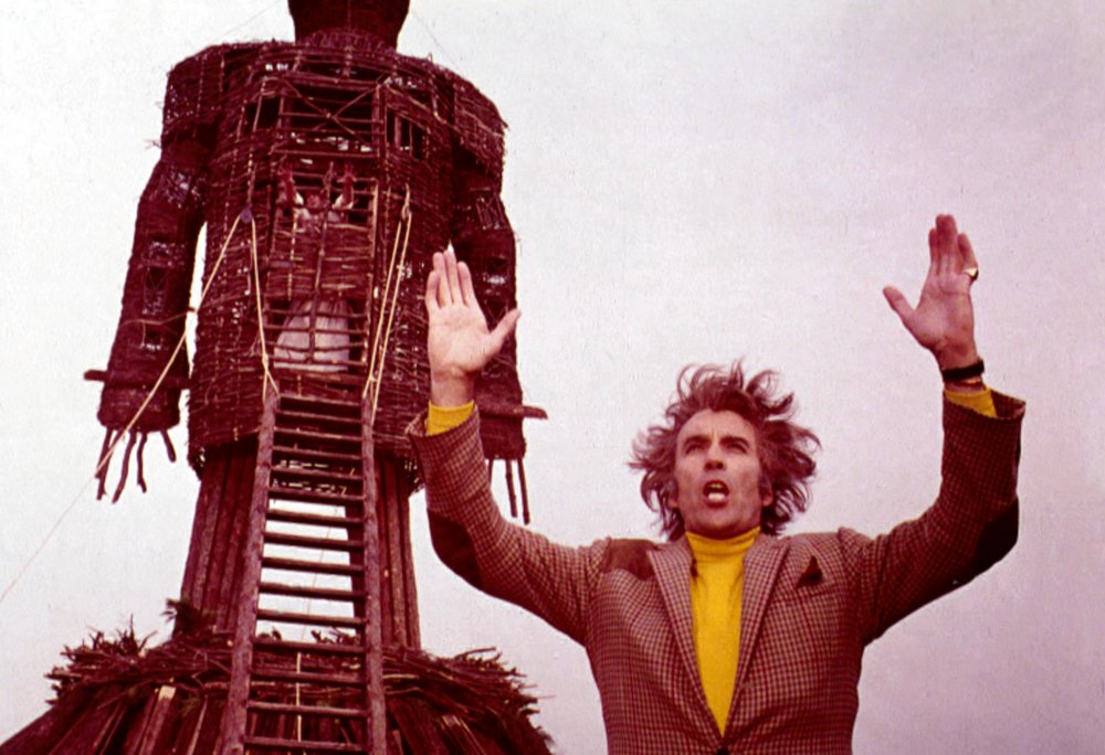 Man standing in front of giant wooden statue.