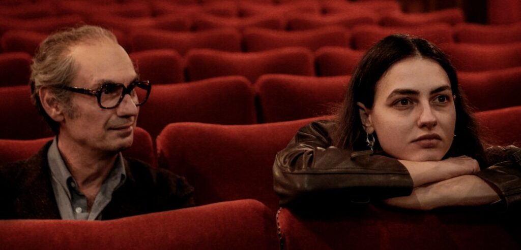 Father and daughter in movie theater seats.