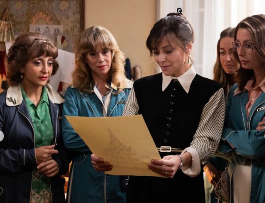Women looking at sketch of dress.