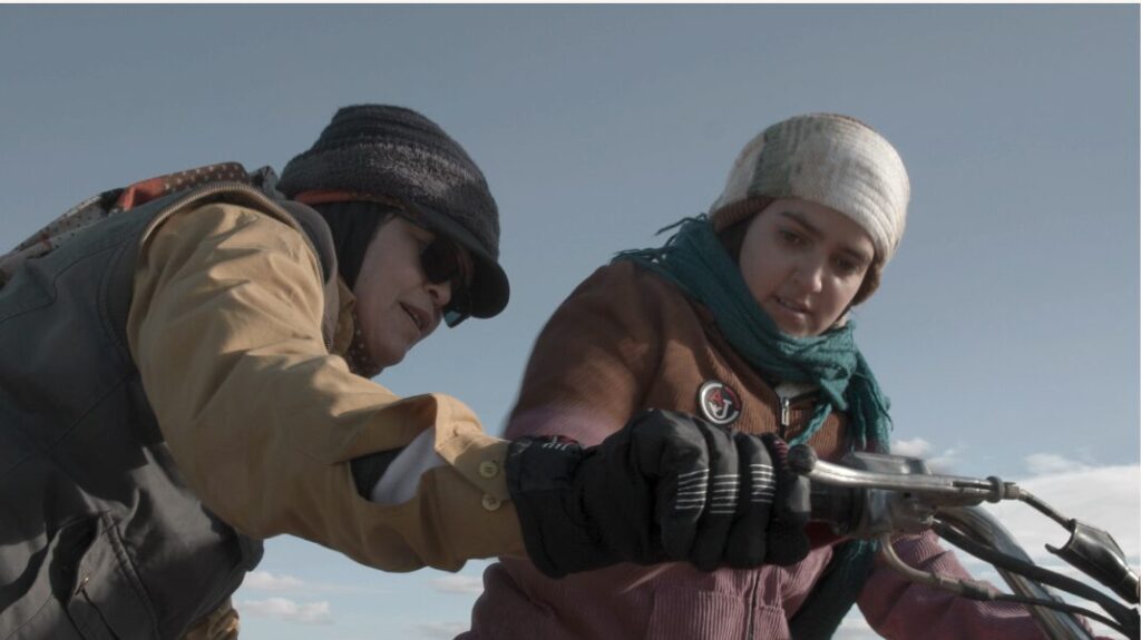 Two people looking at a motorcycle.